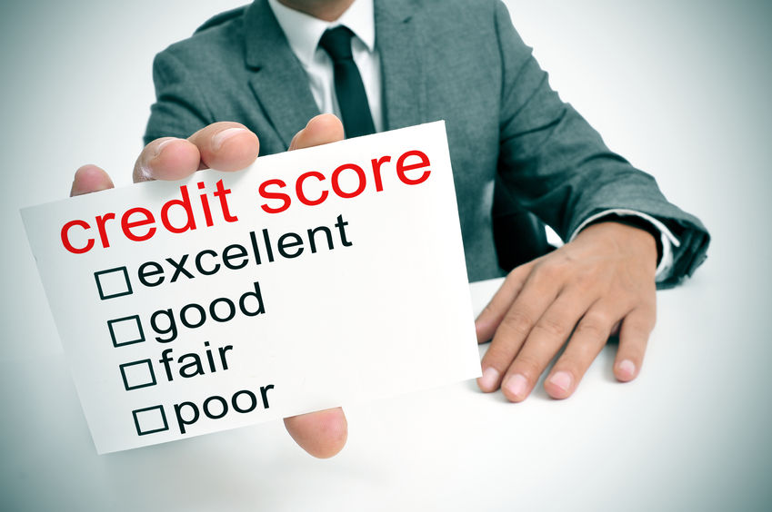 A man holding up a card that reads 'credit score' with boxes to check excellent, good, fair, and poor; suggesting establishing and maintaining good credit