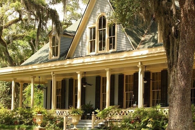 Two story family home among trees, closeup of front porch area; highlighting renewing your mortgage