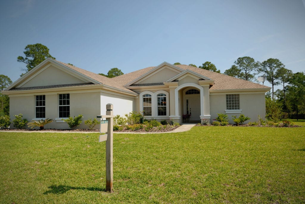 A sold sign in front of a large rancher-style house with green grass; highlighting homebuying made easy