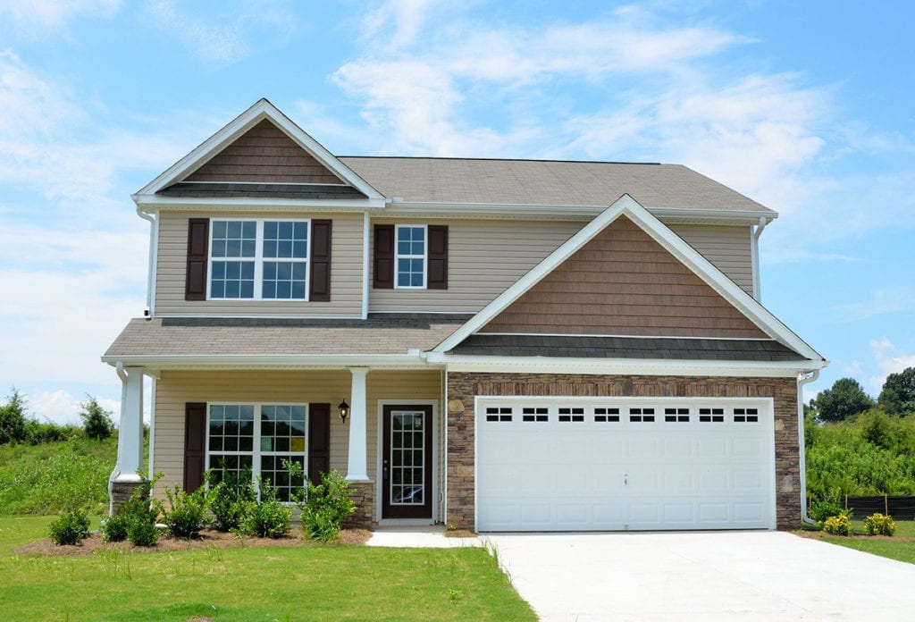 new house for sale upon passing a mortgage stress test; blue sky background and green grass, beige colouring two floors with garage and big windows