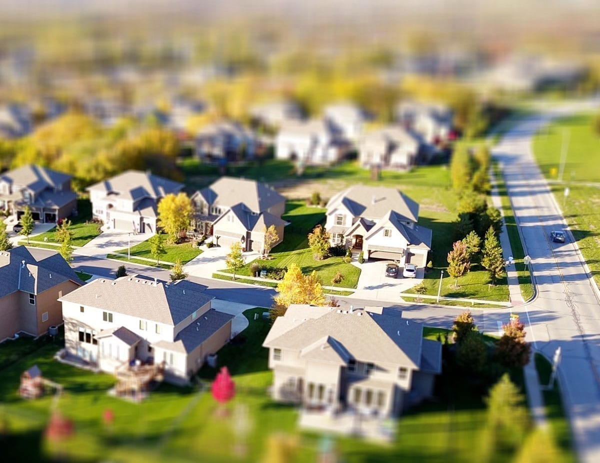 Residential houses from above with a road and green yards; in reference to missed mortgage payments in Kelowna