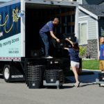 Family packing totes into a moving van, after making the decision between using a mortgage broker or bank for securing a mortgage