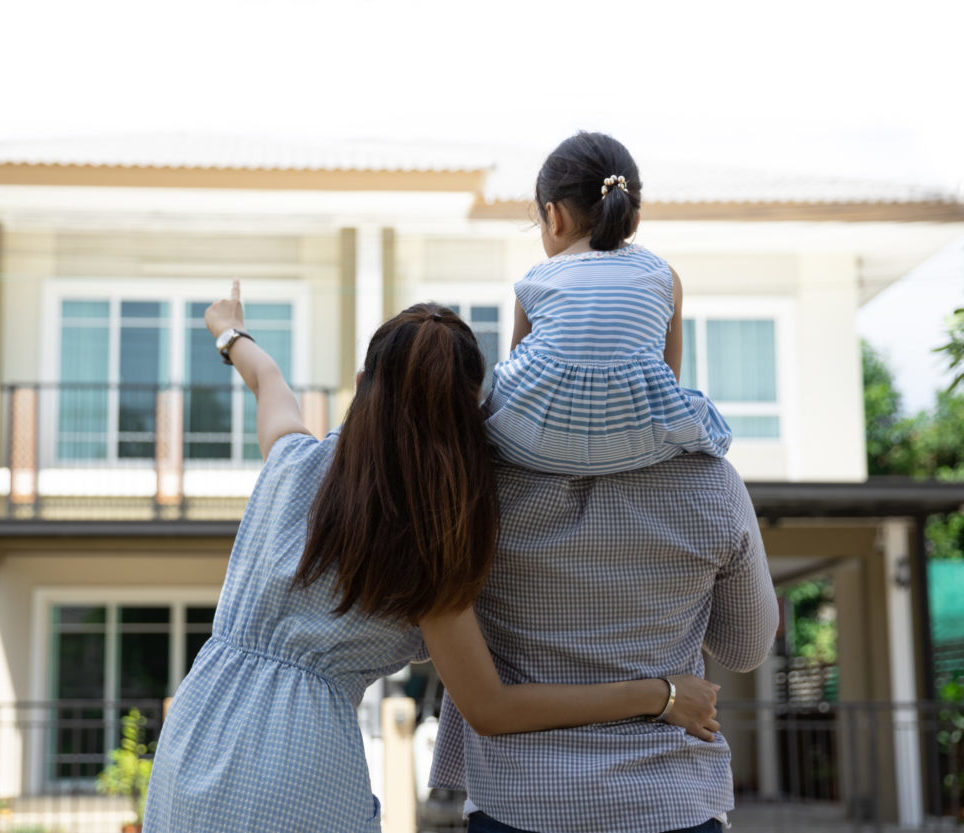 Happy young family. Father, mother and daughter outside of their new home