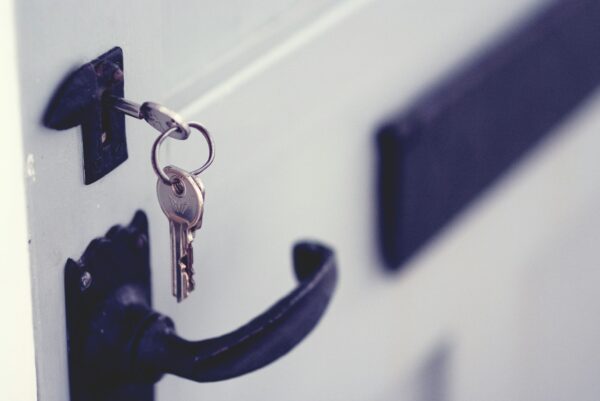 a set of house keys unlocking the front door of a new home after a mortgage approval 
