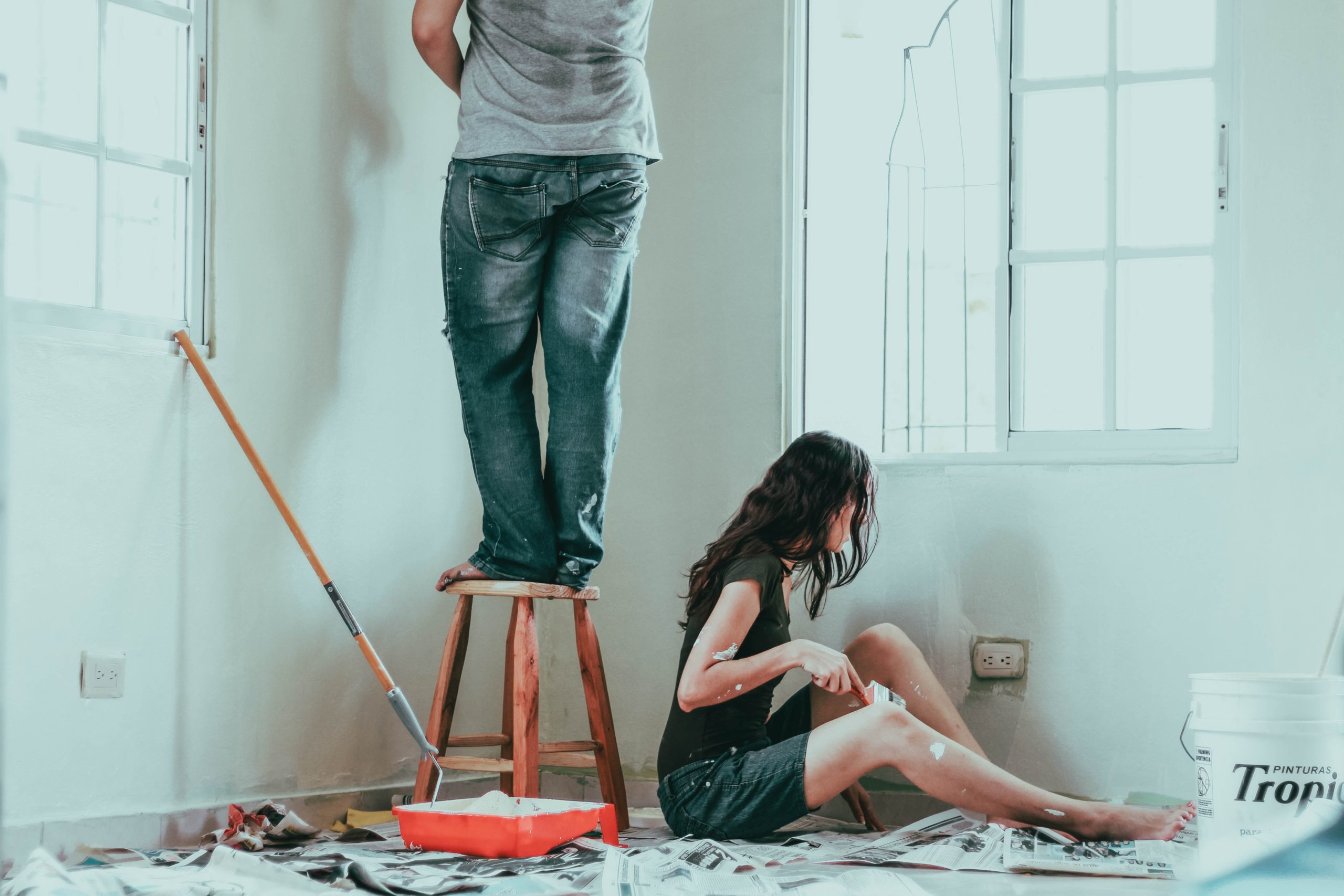 A young couple painting a room in their home together