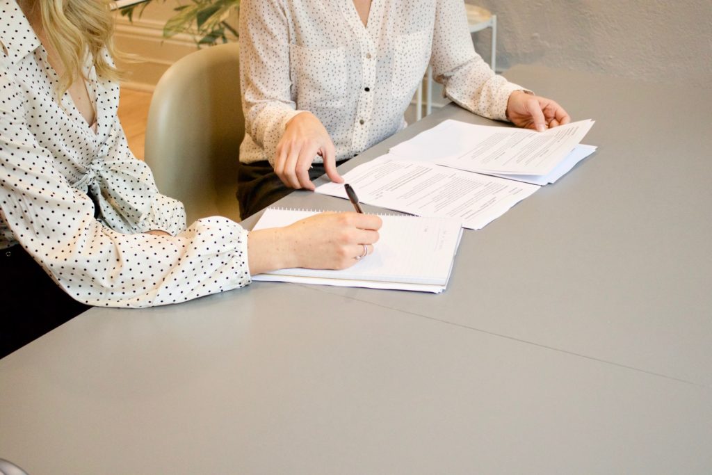 two women sitting at a table filing their income taxes