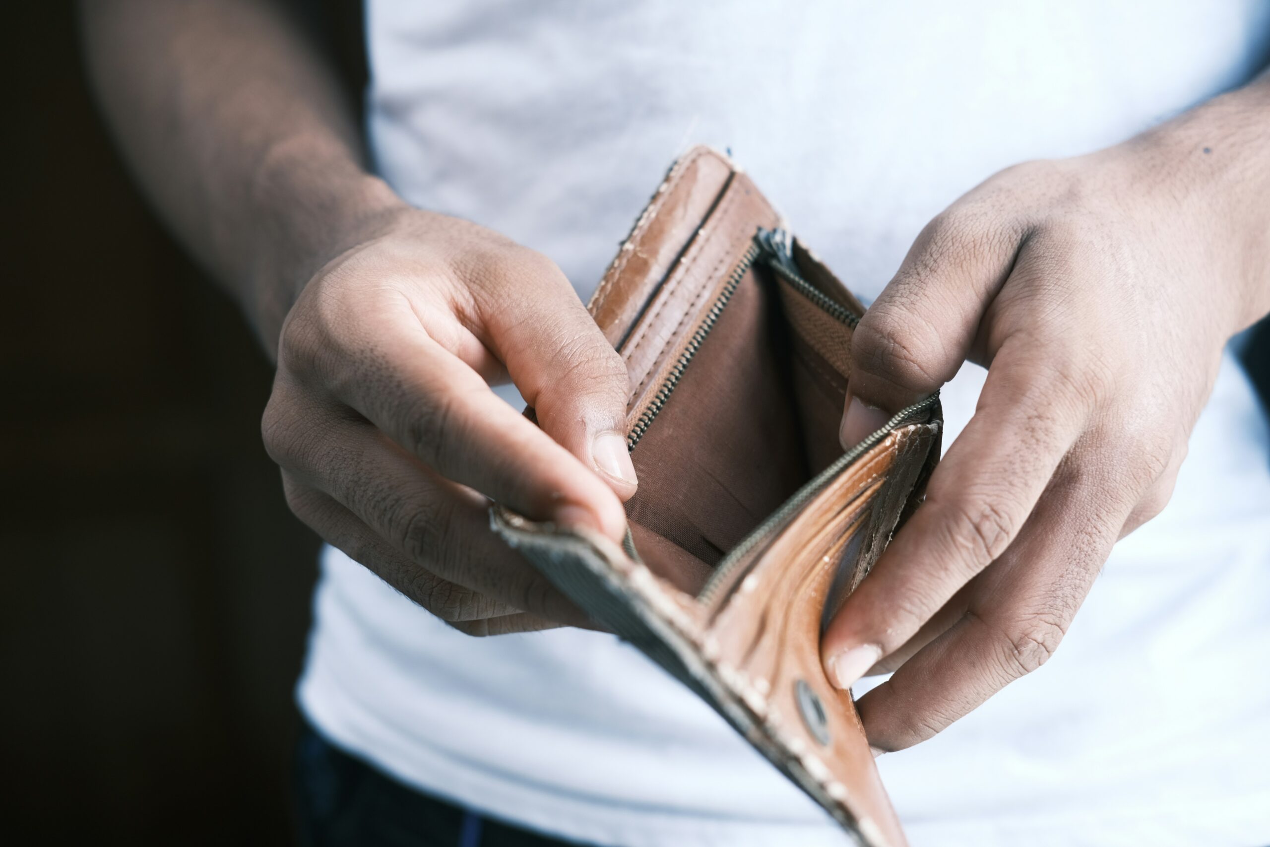 a man with an empty wallet wondering about ways to debt out of debt